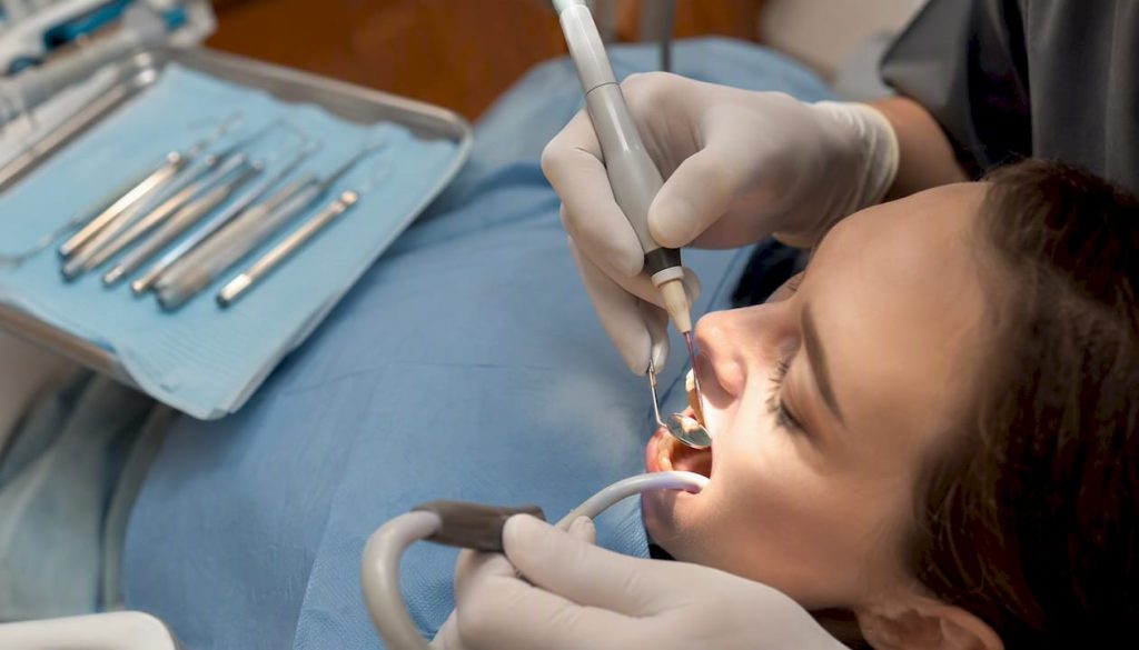 Medic stomatolog care realizează obturarea canalului radicular