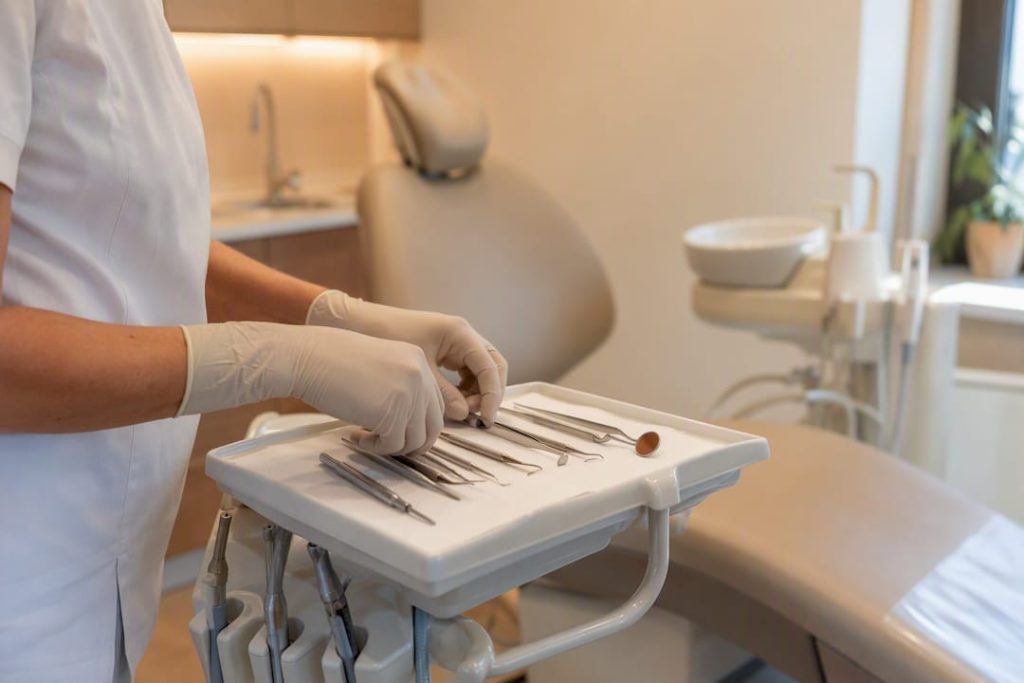 Mâinile dentistului pregătind instrumentele dentare