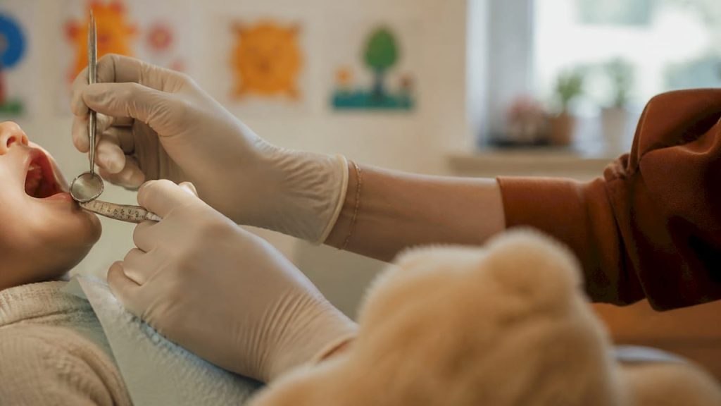 Dentist verificând dinții unui copil mic